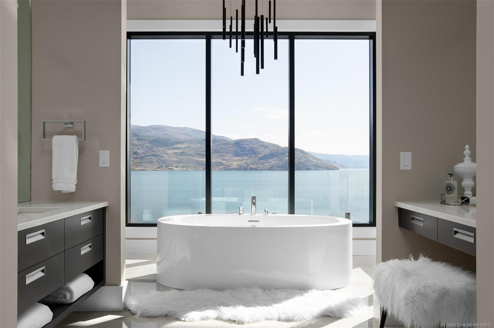 Freestanding tub set against a full-height window with a mountain view