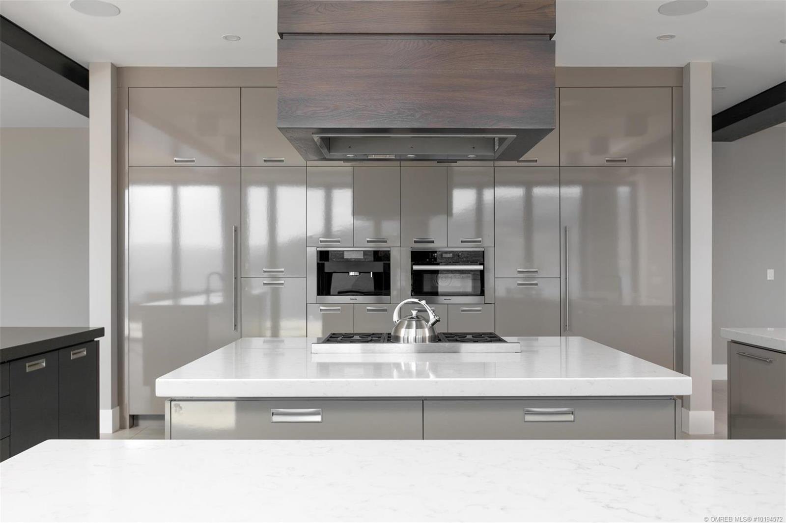 Handleless gloss galley kitchen with a stainless steel hood