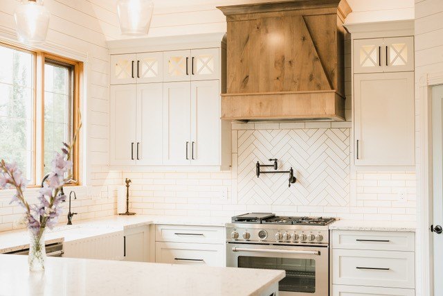 White shaker kitchen with a knotty timber range hood