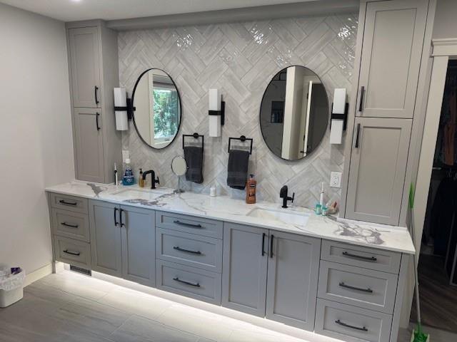 Grey double vanity below two arched mirrors