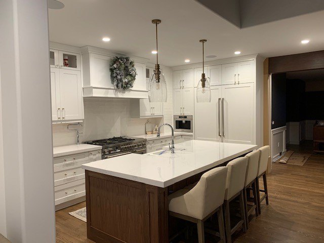 White kitchen with a long island and upholstered stools
