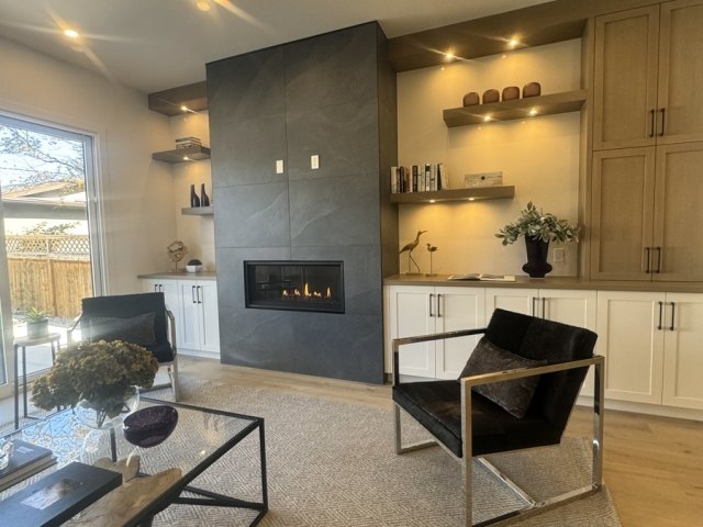 Living room fireplace flanked by timber built-in shelving and cabinets